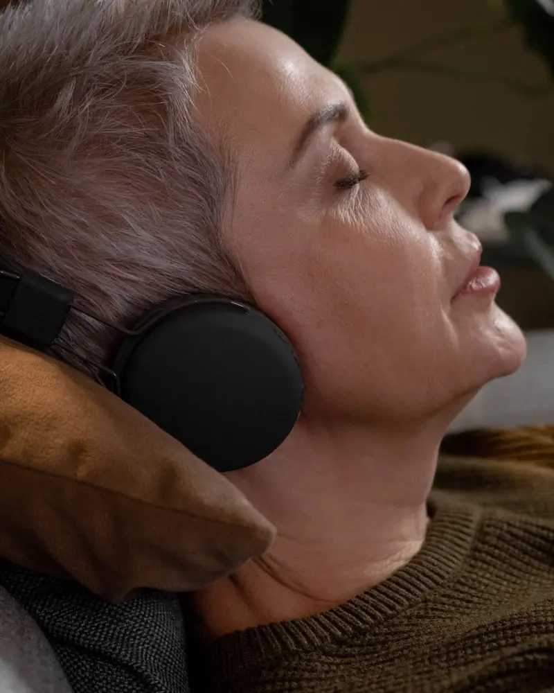 A woman relaxing with headphones, eyes closed